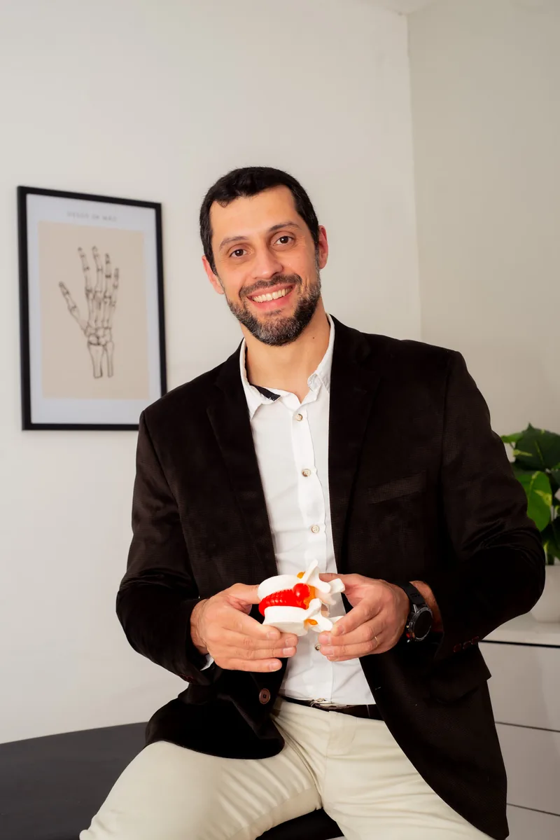 Dr. José Carlos com um modelo anatômico de vértebra e disco intervertebral